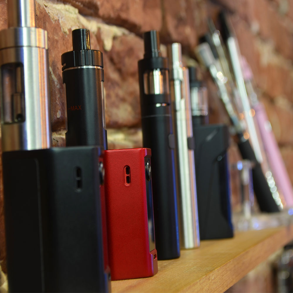 Box mod vapes and vape pens on a shelf